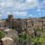 Villaggio medievale pittoresco, con strade acciottolate e edifici storici, perfetto per un set cinematografico.